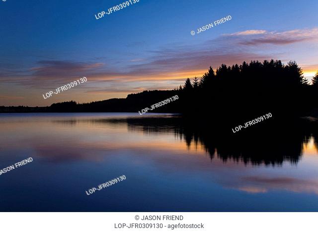 Scotland, Scottish Borders, Alemore Loch, Sunrise reflected in the tranquil waters of the Alemoor Loch, a popular place for recreational fishing near the town...
