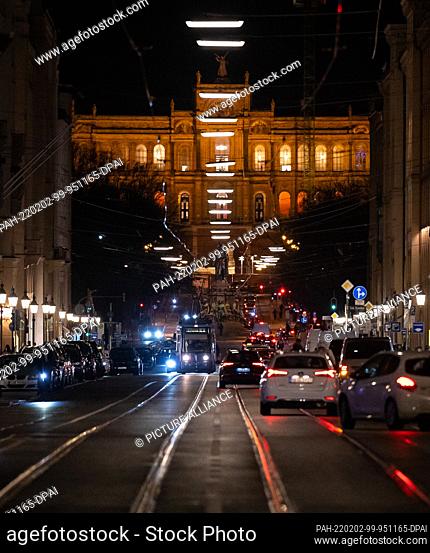 02 February 2022, Bavaria, Munich: Cars drive along Maximilianstrasse. In the background you can see the Maximilianeum, seat of the Bavarian Parliament