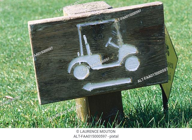 Wooden sign with golf cart and arrow