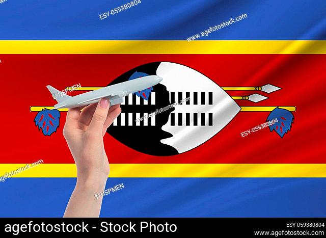 Airplane in hand with national flag of Esvatini Travel to Esvatini