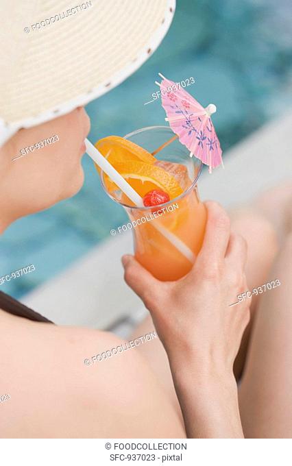 Woman drinking Planter's Punch by pool