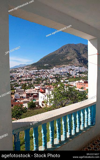 The city of Chefchaouen is visible through an open balcony.; Chefchaouen , Morocco