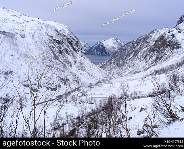 Valley of Botnelva and mountain road Kaperdalsveien, in the background Sifjorden. The island Senja during winter in the north of Norway