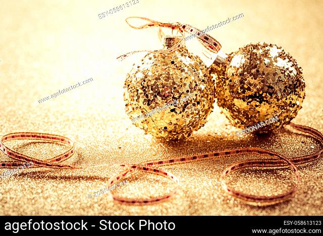 Golden christmas balls on glitter background with copy space. Glitter background