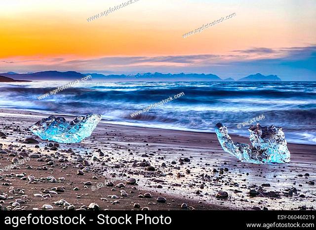 Incredible pieces of the iceberg sparkle on famous Diamond Beach at Jokulsarlon lagoon during sunset. Location: Jokulsarlon lagoon, Diamond beach