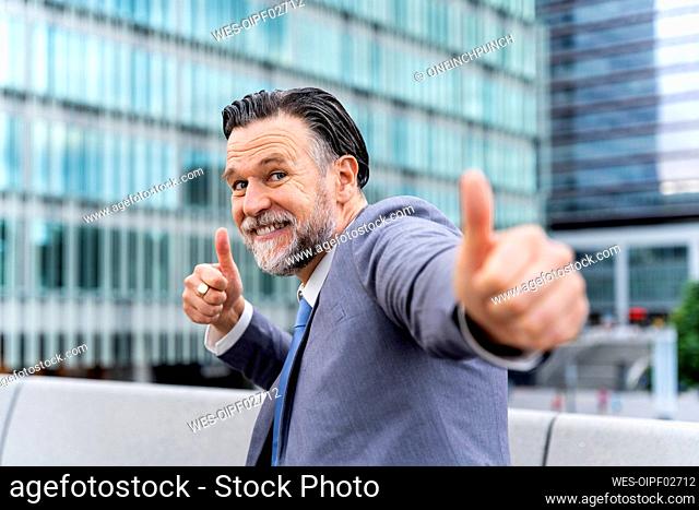 Happy mature businessman showing thumbs up