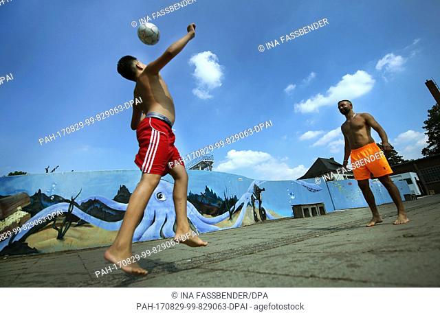 The brothers Ahmed (l) and Mo play soccer at the Stadionbad open air pool in Dortmund, Germany, 29 August 2017. Photo: Ina Fassbender/dpa