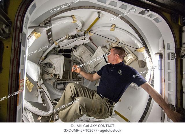 NASA astronaut Chris Cassidy, Expedition 36 flight engineer, works with spacewalk equipment in the Quest airlock of the International Space Station in...