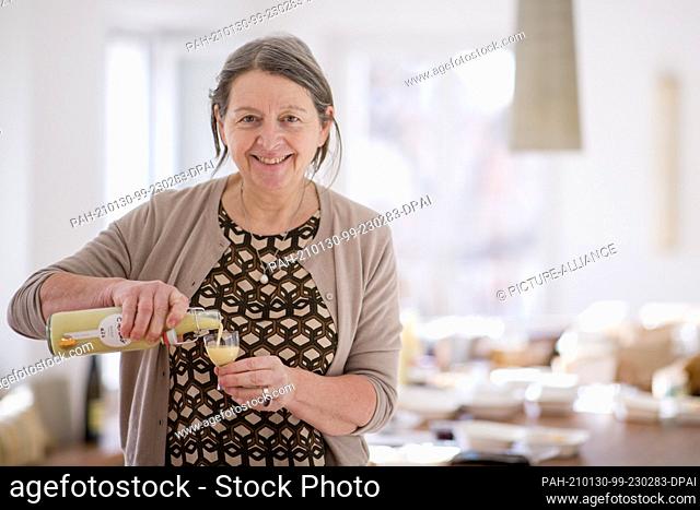 22 January 2021, Bavaria, Nuremberg: Gabriele Hussenether, owner of the Mobile Kochkunst cooking school, stands in front of a table of pre-ordered takeout food