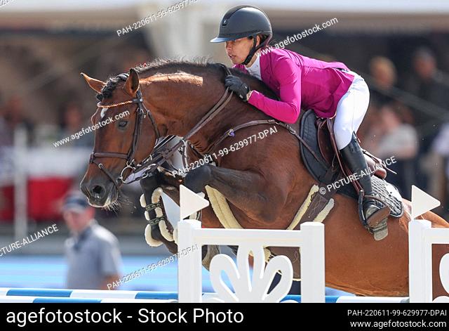 11 June 2022, North Rhine-Westphalia, Balve: Equestrian sport: German championship, ladies, show jumping. Showjumper Tina Deuerer rides Clueso 10 at the German...