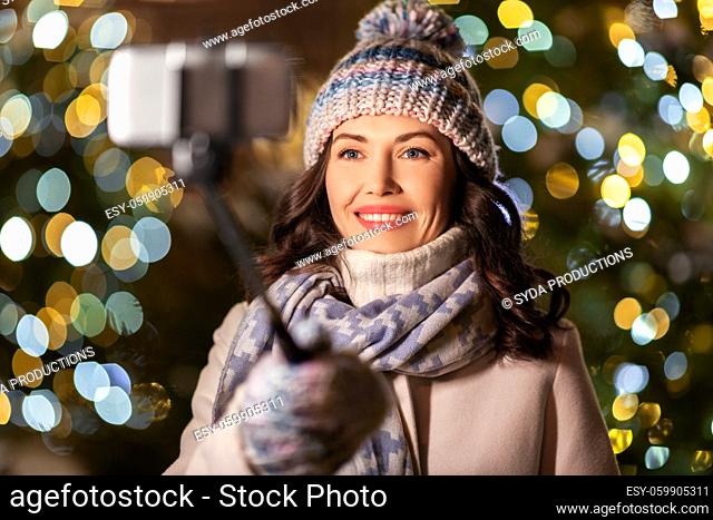 happy woman taking christmas selfie on smartphone