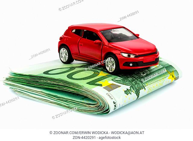 Ein Auto steht auf Euroscheinen. Kosten für Autokauf, Benzin, Versicherung und andere Autokosten