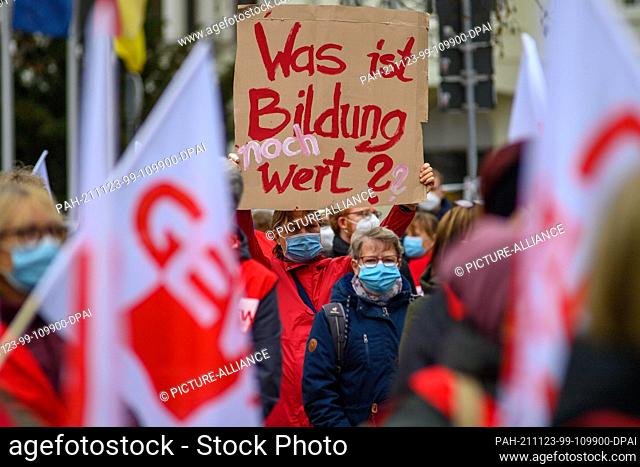23 November 2021, Saxony-Anhalt, Magdeburg: ""What is education still worth?"" can be read on a cardboard sign during a warning strike in front of the Ministry...