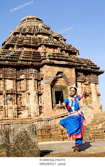 Odissi dancer strike pose re-enacts Indian myths such as Ramayana in front of world heritage Sun temple complex in Konarak , Orissa , India MR400