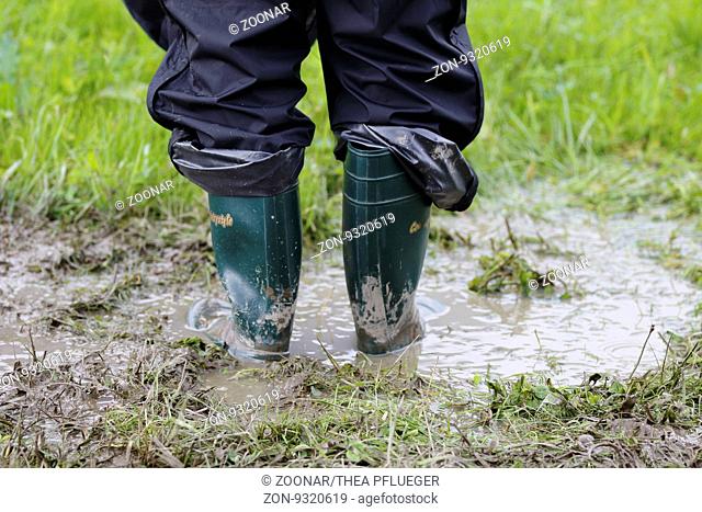 Rubber boots in use with rain paints. Wellington boots. Gumboots