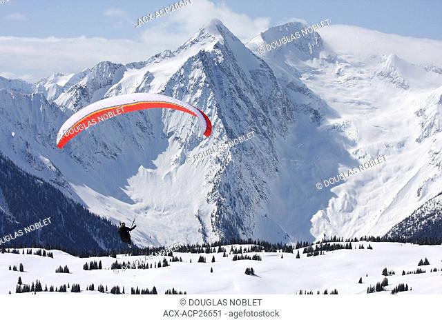 Paraglider flying near Mt Cooper, Northern Selkirks BC, Canada