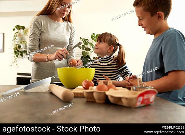 Girl with sister and brother preparing cookies at home