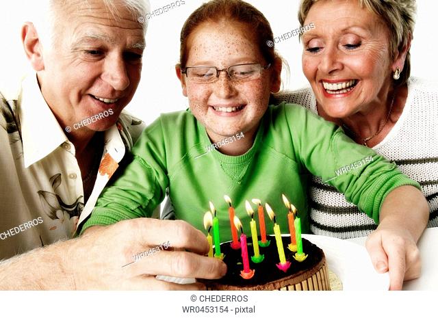 Close-up of a granddaughter celebrating her birthday with her grandparents