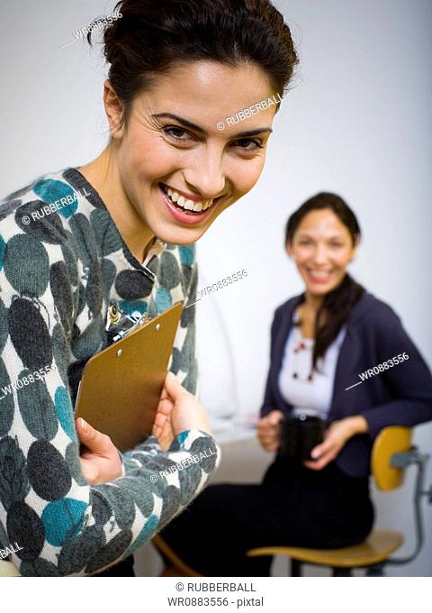 Portrait of a young woman laughing with her co-worker