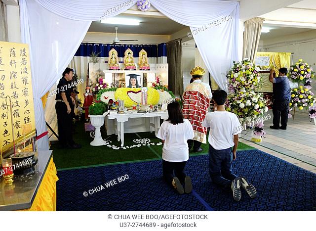 Sister and cousin kneeled down to pay their last respect to the late sister. Sarawakian chinese funeral ceremony. Malaysia