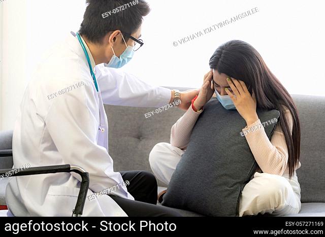 Portait of asian female patient with face mask talking to Psychotherapist doctor for consult about her mental health after stress strain from quarantine from...