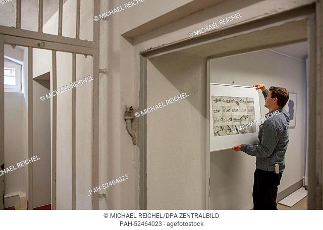 Michael Kirsten hangs a picture in the art exhibition ""so nah... weit fern: Bilder aus der Hafterfahrung"" (So near...far away: pictures of the prison...