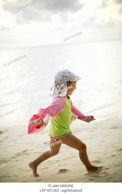 Girl running along beach, Biyadhoo Island, South Male Atoll, Maldive Islands