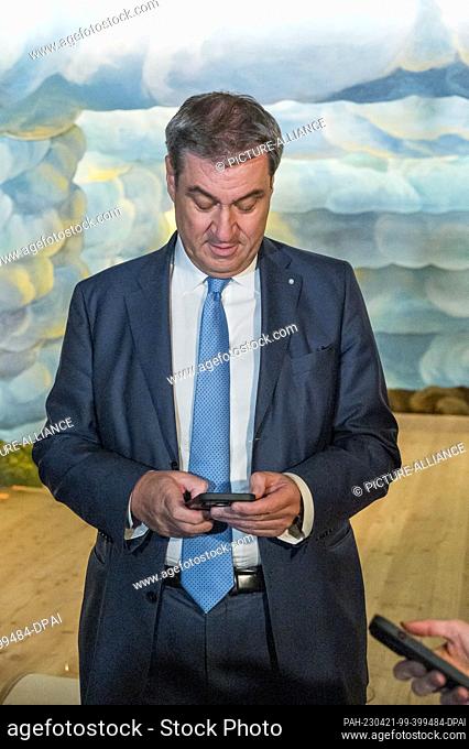 21 April 2023, Bavaria, Bayreuth: and Markus Söder (CSU), Bavarian Minister President, looks at his smartphone at the opening of the Opera House Museum with...