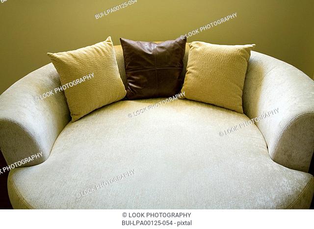 Circular sofa bed with three throw pillows