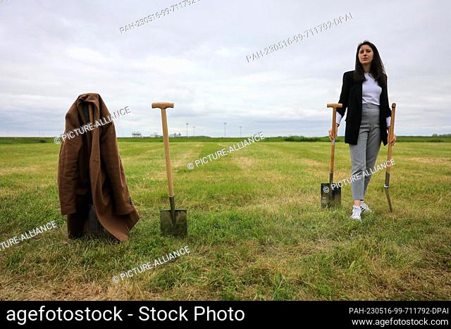 16 May 2023, Saxony, Schkeuditz: A young woman waits for a groundbreaking ceremony for a new aircraft production hall at Leipzig/Halle Airport