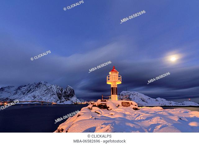 Lighthouse and full moon in the Arctic night with the village of Reine in the background Nordland Lofoten Islands Norway Europe