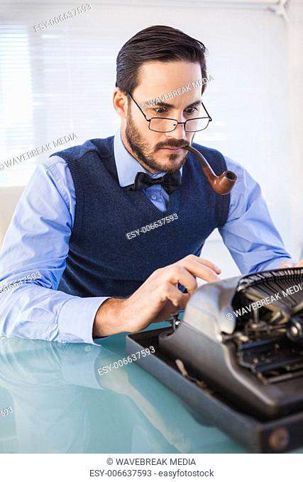Businessman with pipe in his mouth working on typewriter