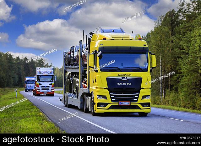 New MAN TGX car carrier truck transports vehicles in highway heavy traffic on a day of autumn. Raasepori, Finland. September 9, 2021