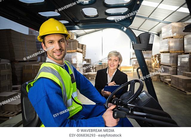 Warehouse worker and his manager smiling at camera