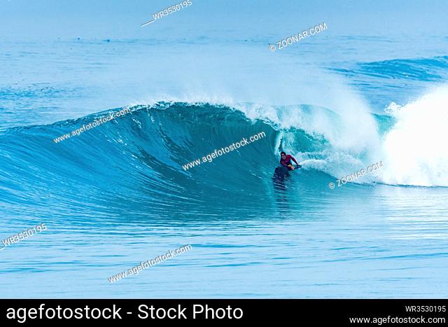 Bodyboarder surfing ocean wave on a sunny day
