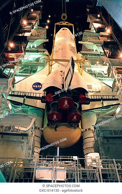 12/03/1999 -- Lights frame the orbiter Endeavour as it is lowered onto the platform for mating with the external tank and solid rocket boosters