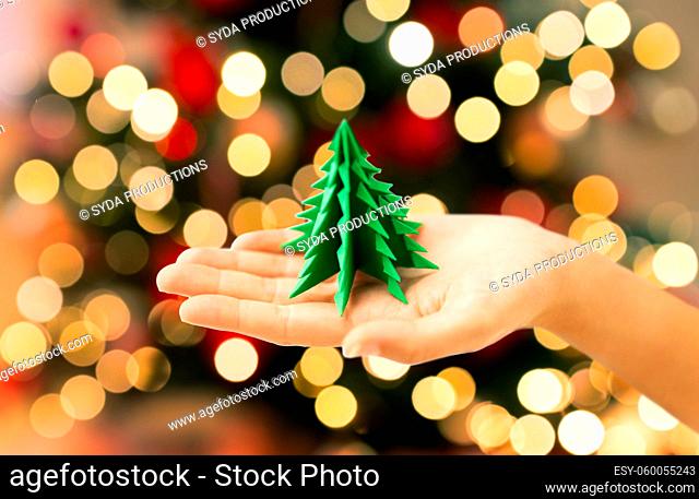 hand holding green paper origami christmas tree