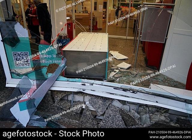 04 May 2021, Hamburg: Shards of glass and stones of a destroyed shop window frame lie after an accident in a Haspa branch