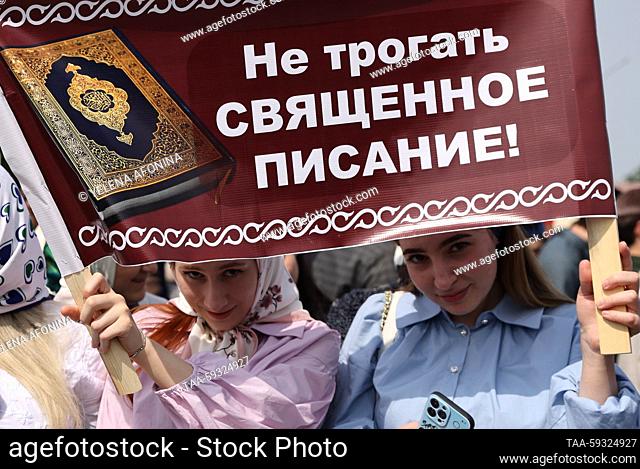 RUSSIA, GROZNY - MAY 23, 2023: People hold a banner reading ‘Do not touch the holy scripture!’ during a rally staged in Grozny after a citizen of Volgograd...