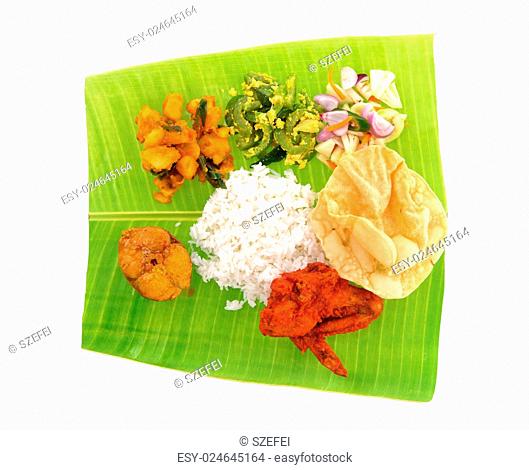 Overhead view of full length Indian banana leaf rice isolated on white background