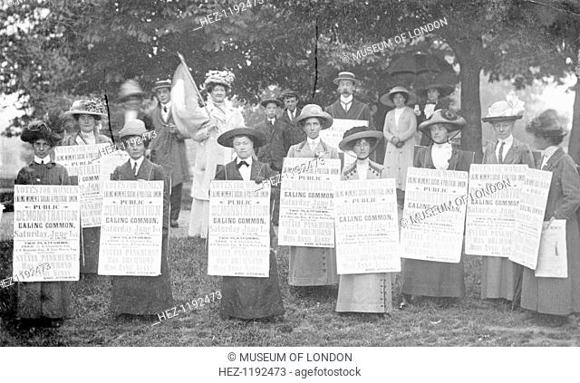 A 'poster parade' of Ealing suffragettes advertising a meeting to be held on Ealing Common, 1st June 1912. Wearing sandwich boards advertising the meeting