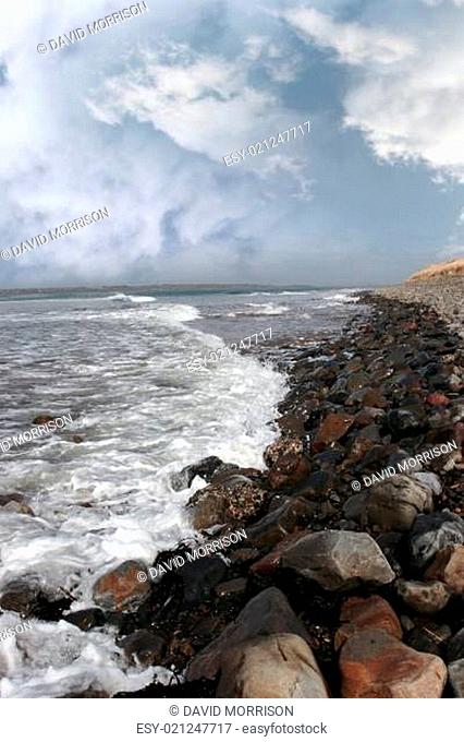 rolling waves on pebbled coastline