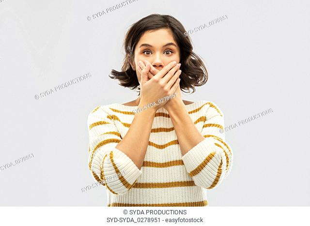 shocked young woman covering her mouth by hands