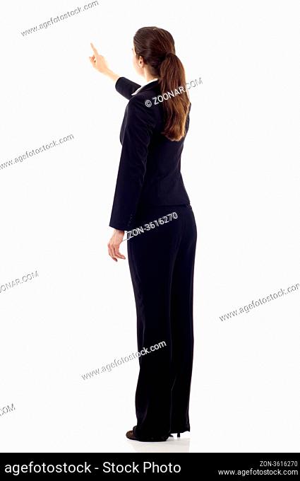 Full body of young business woman pointing at something from the back, isolated over white background