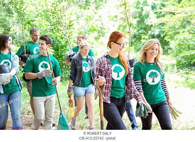 Smiling environmentalist volunteers planting new tree