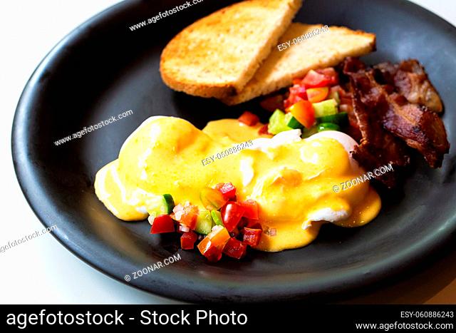 Eggs Benedict - bread , becon and tomato, poached eggs, and delicious buttery hollandaise sauce
