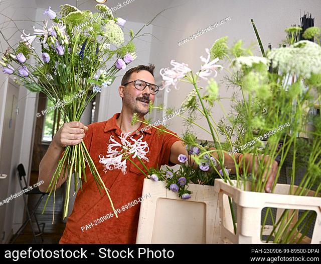 22 August 2023, Berlin: Florist Nicolaus Peters ties a bouquet of different flowers. He will be taking part in the World Cup of Florists in Manchester for...