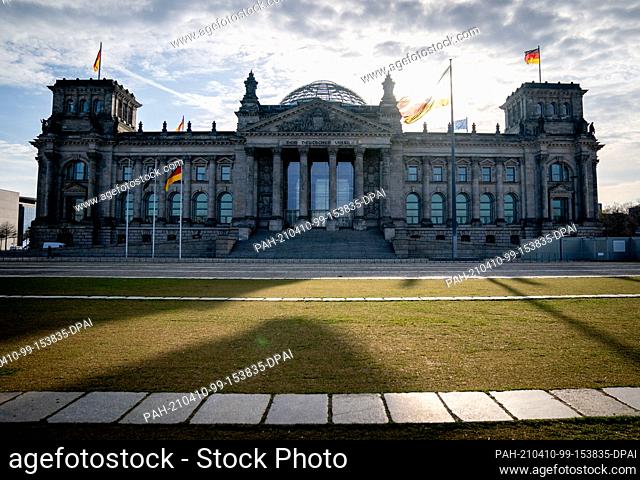 09 April 2021, Berlin: The sun is behind the Reichstag building with the Bundestag in the morning. The leaders of the government factions of the Union and SPD...