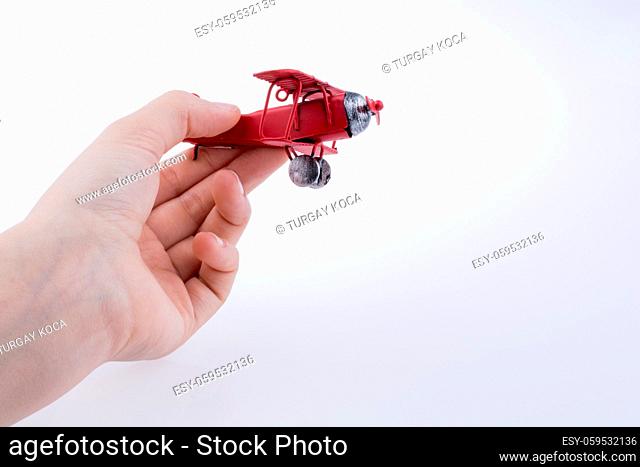 Hand holding a red Plane on a white background