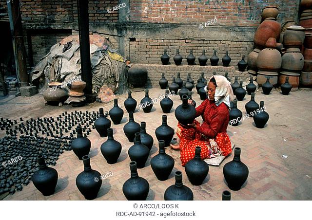 Woman decorating earthenware jugs at the Pottery market, Potters' Square, Bhaktapur, Nepal
